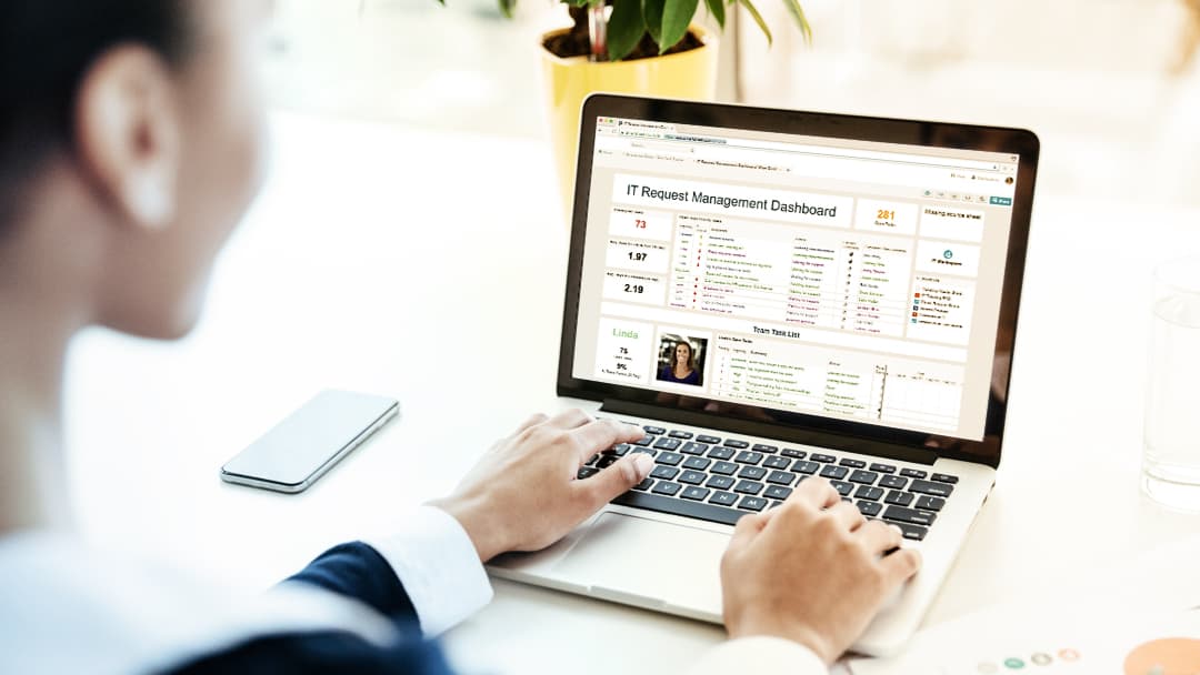 A businesswoman reviews data displayed on a Smartsheet dashboard