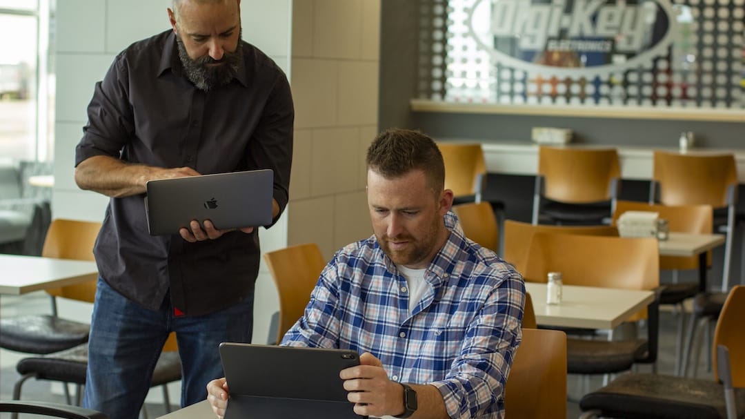 Employees work on a tablet and laptop in the Digi-Key cafeteria 