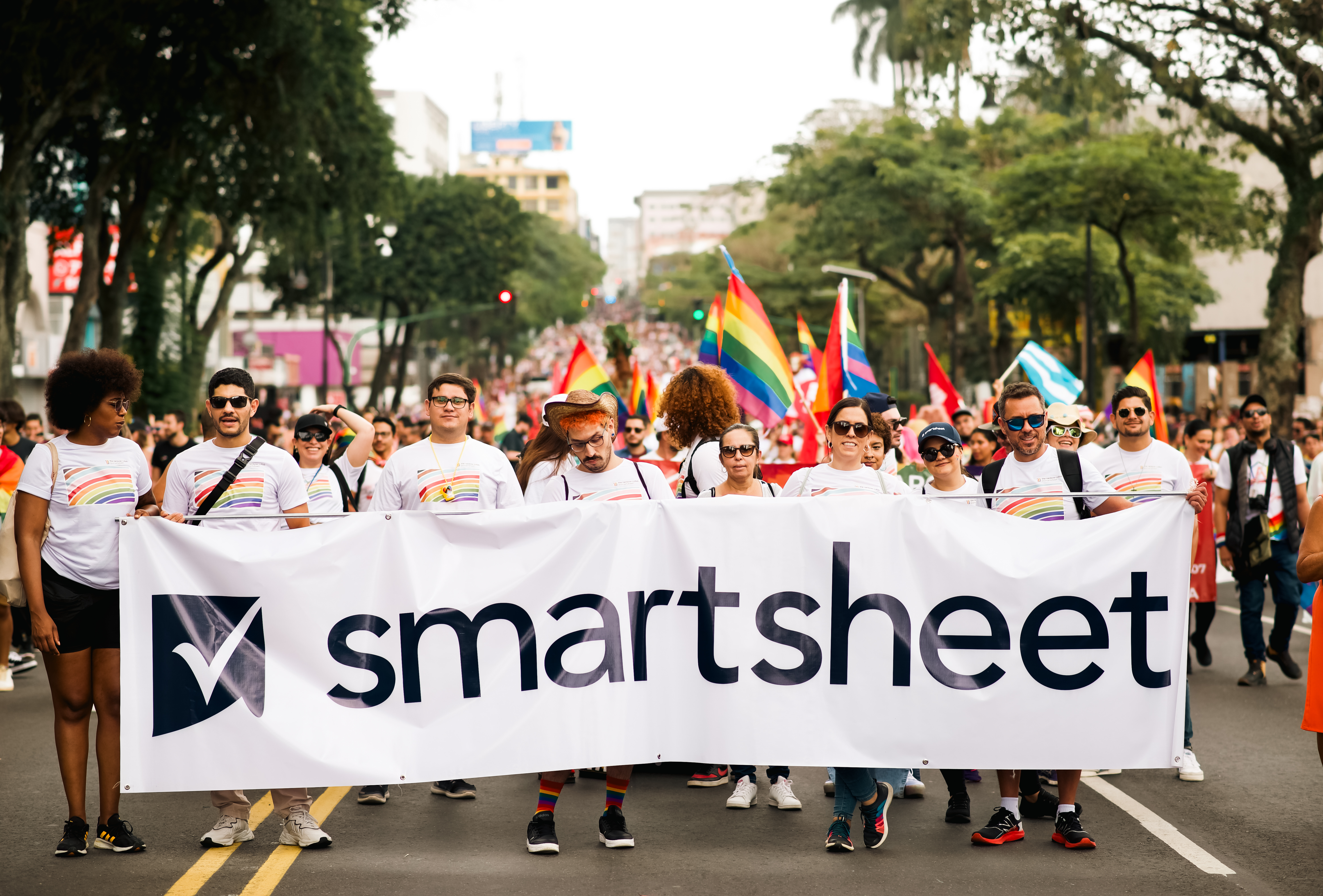 Group of people holding Smartsheet banner at a Pride Parade