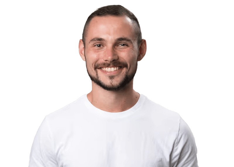 A man in a white shirt with a beard smiling