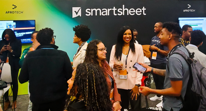 Black@Smartsheet ERG members socialize with other AFROTECH Conference attendees in front of the Smartsheet booth.